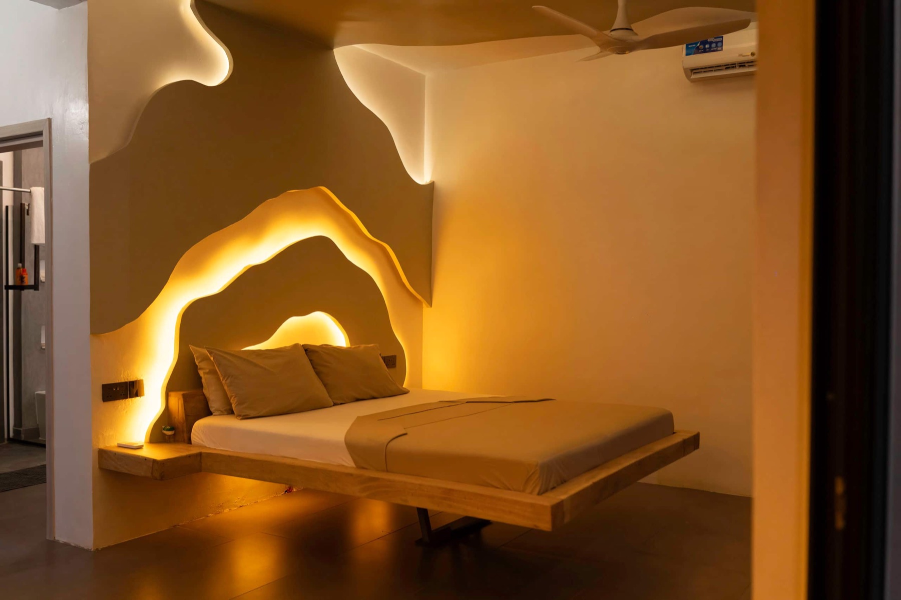 An ensuite bedroom with a sculptural headboard